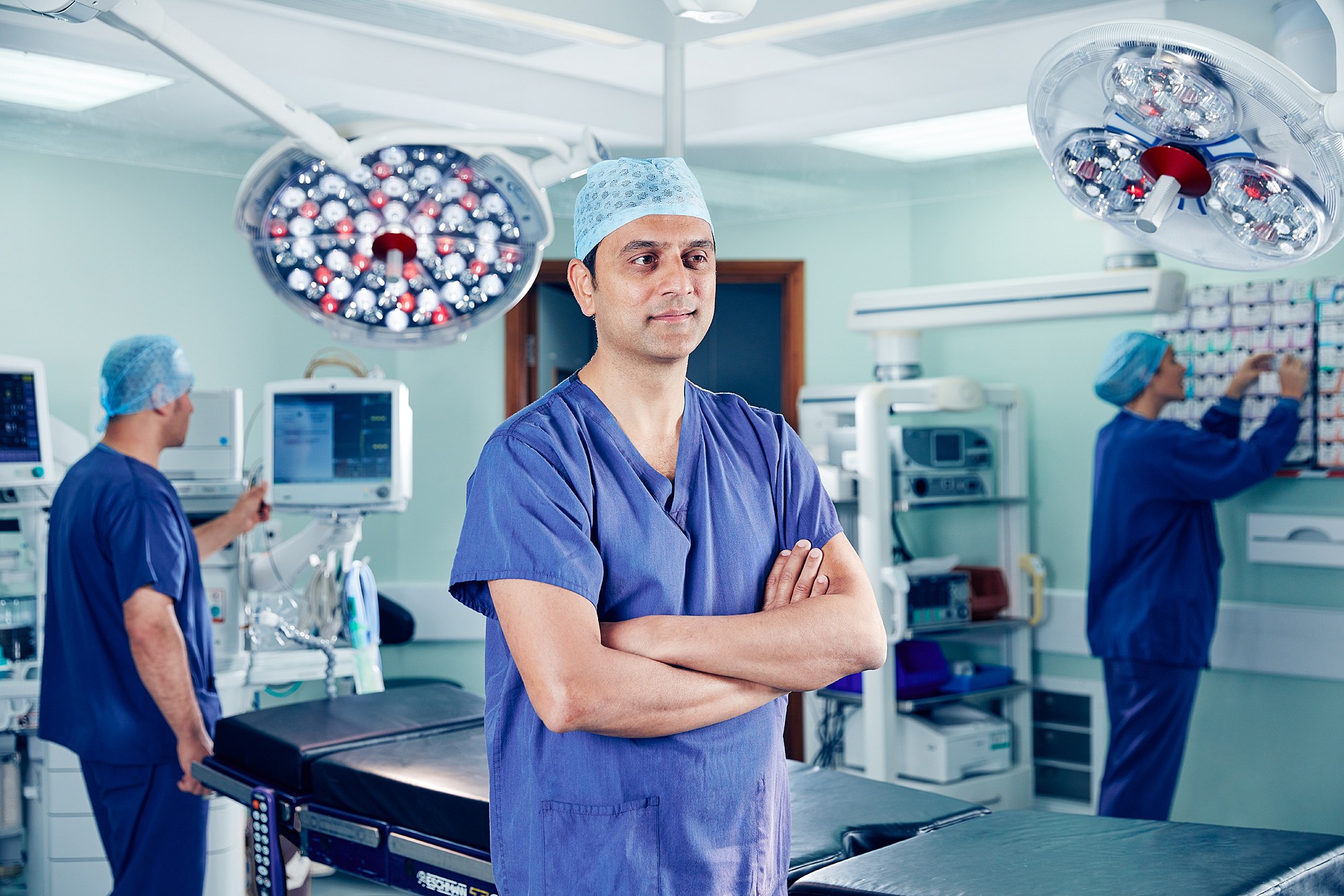 Portrait of a consultant in scrubs and surgical cap in an operating theatre